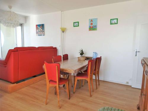 - une salle à manger avec un canapé rouge, une table et des chaises dans l'établissement Détroit Saint Gilles Croix de Vie, à Saint-Gilles-Croix-de-Vie