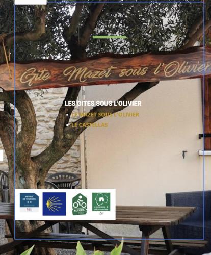 a sign for a cafe named some sorts of furniture next to a tree at Les Gîtes sous l' Olivier en Camargue in Vauvert