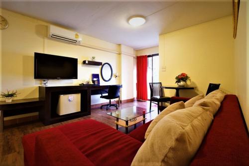 a living room with a couch and a flat screen tv at Vabua Asotel Bangkok in Bangkok