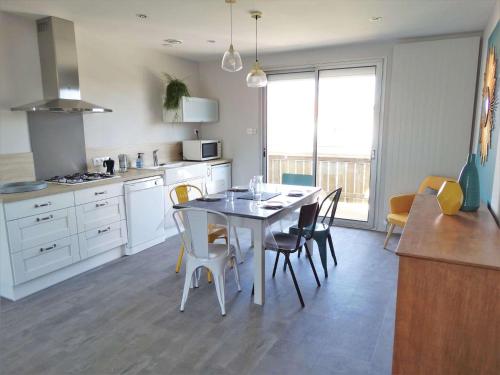 une cuisine avec une table et des chaises dans une pièce dans l'établissement Crevette Saint Gilles Croix de Vie, à Saint-Gilles-Croix-de-Vie