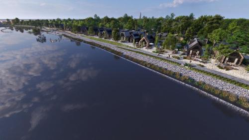 a river with a row of houses on the shore at Beach villa at the IJsselmeer 8p in Enkhuizen