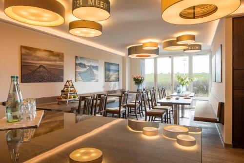 a restaurant with tables and chairs and windows at MeerBlickD21 in Norderney