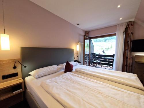 a bedroom with a large white bed and a window at Mosers Blume Relax & Genuss Hotel in Haslach im Kinzigtal