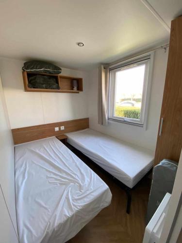 une petite chambre avec deux lits et une fenêtre dans l'établissement K107 Charmettes, aux Mathes