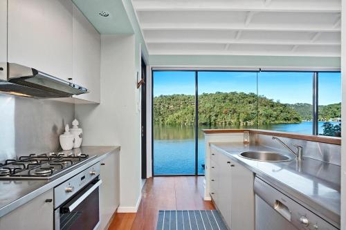 a kitchen with a large view of the water at Berowra Waters Glass House in Berrilee