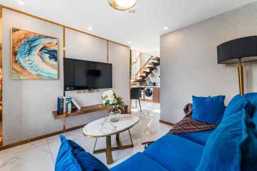 a living room with a blue couch and a table at 云享城居 SKY高空Loft公寓酒店 春熙路九眼桥店 in Chengdu