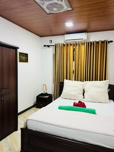 a bedroom with a bed with a green blanket on it at Nima villa in Tangalle