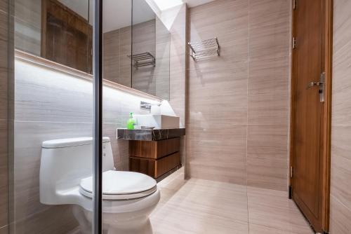 a bathroom with a toilet and a shower at Puhai Sea View Apt by Hailan Tour at Sanya Yazhou Bay#only 100 meters to Beach and Sea Swimming Area in Sanya