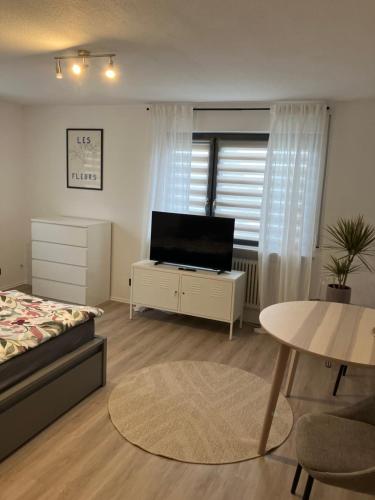 a bedroom with a bed and a tv and a table at Apartment Anna in Inzigkofen