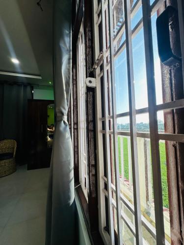 a room with a window with a view of a field at Ranghar Homestay Sivasagar in Sivasagar