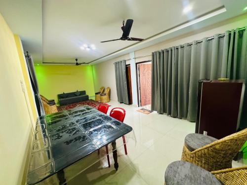 a dining room with a glass table and chairs at Ranghar Homestay Sivasagar in Sivasagar