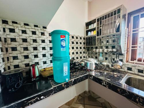 a blue water bottle sitting on a counter in a kitchen at Ranghar Homestay Sivasagar in Sivasagar