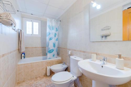 a bathroom with a white toilet and a sink at Azalea - Stylish Apartment with Rooftop & Pool in Los Altos