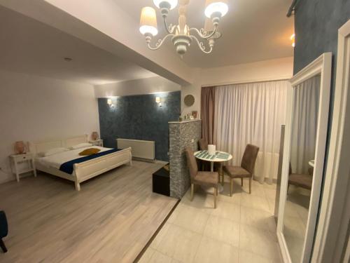 a bedroom with a bed and a table and chairs at TEN APARTAMENT in Eforie Nord