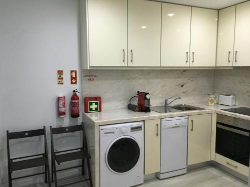 a kitchen with white cabinets and a washing machine at Casa da Praça - O Seu Refúgio no Coração Histórico de Aveiro in Aveiro