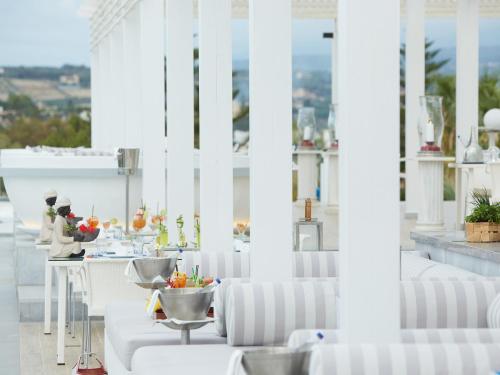 a white room with white chairs and a table at Grecotel Creta Palace in Rethymno Town