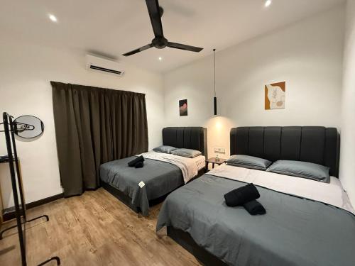 a bedroom with two beds and a ceiling fan at Mujito3 4BR 16PAX InTown, PoolTable, PS4, Netflix in Kuantan