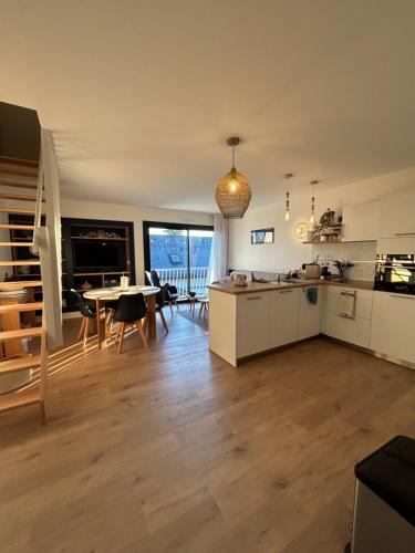 a kitchen and living room with a table and chairs at Au pied du GR 34 in Fouesnant