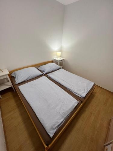 a bedroom with two beds and a desk with a lamp at Apartmán s výhledem na moře in Vir