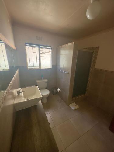 a bathroom with a toilet and a sink and a shower at Kliprand Guest House in Springbok
