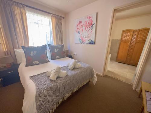 a bedroom with a bed with two stuffed animals on it at Kliprand Guest House in Springbok