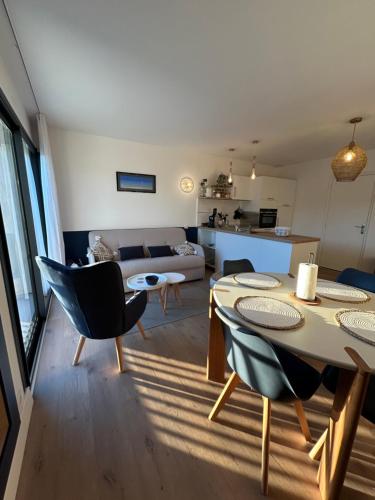 a living room with a table and chairs and a couch at Au pied du GR 34 in Fouesnant