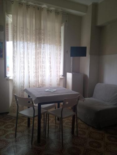 a living room with a table and chairs and a couch at MONOLOCALI DA VINCI in Falconara Marittima