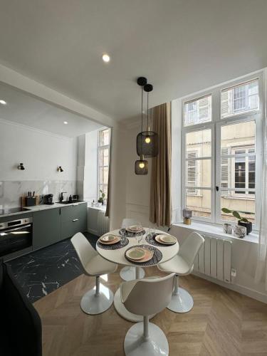 une cuisine avec une table et des chaises dans une pièce dans l'établissement Spacieux, plein centre refait à neuf, à Vienne