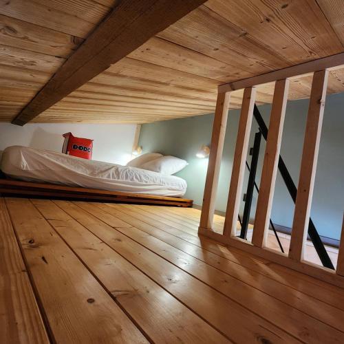 une chambre avec un lit et un parquet dans l'établissement Studio Hautes Vosges, à La Bresse