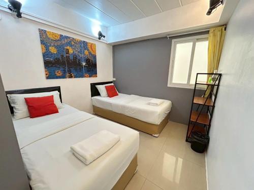 a room with two beds and a painting on the wall at Khaosan Art Hotel in Bangkok