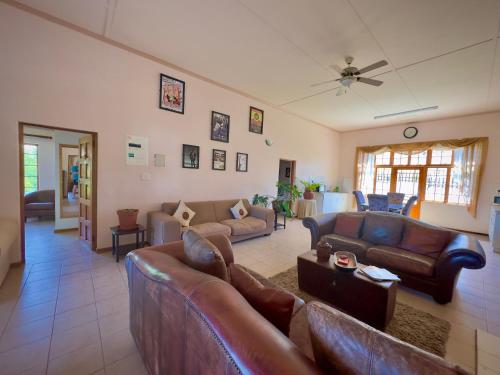 a living room with leather couches at Kliprand Guest House in Springbok