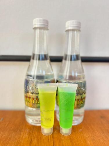 two empty bottles sitting on a table with two drinks at Khaosan Art Hotel in Bangkok