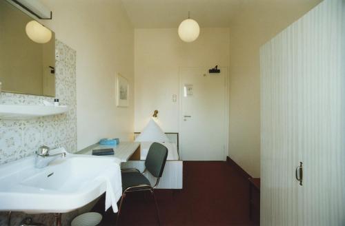 a bathroom with a white sink and a mirror at Hotel Jedermann in Munich