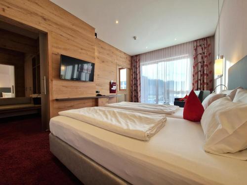 a hotel room with two beds and a flat screen tv at Mosers Blume Relax & Genuss Hotel in Haslach im Kinzigtal