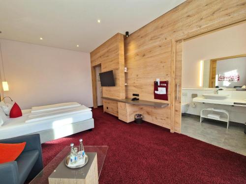 a hotel room with a bed and a sink at Mosers Blume Relax & Genuss Hotel in Haslach im Kinzigtal