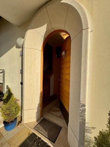 an arched entryway to a house with a wooden door at Mansarda da Nonna Berbelina in Belluno