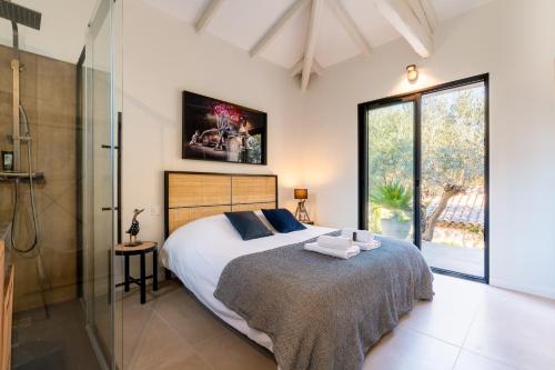 - une chambre avec un grand lit et une douche en verre dans l'établissement Villa Armonía piscine privée sur le golf Béziers, à Béziers