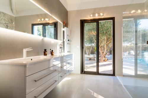 une cuisine blanche avec un évier et une grande fenêtre dans l'établissement Villa Armonía piscine privée sur le golf Béziers, à Béziers