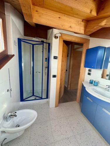a bathroom with a sink and a glass shower at Mansarda da Nonna Berbelina in Belluno