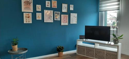 a living room with a tv on a blue wall at Canaletto apartment con parcheggio in Dolo