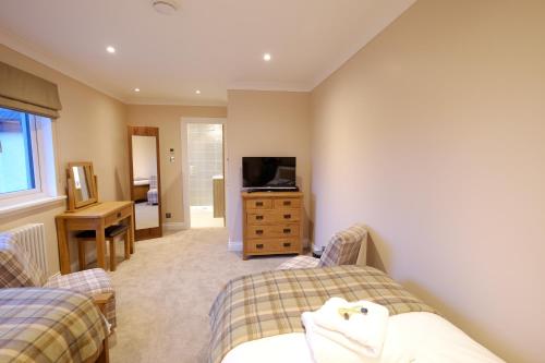 a bedroom with two beds and a television in it at The Tide in Dunvegan