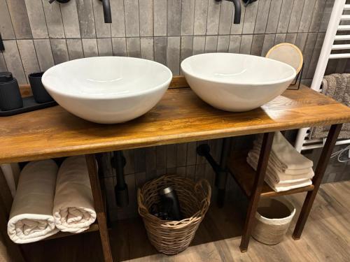 two white bowls on a wooden counter in a bathroom at B&B Villa la Canonica con piscina a Padernello in Farfengo