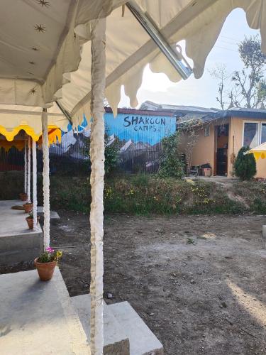 a large white tent in front of a building at Shakoon Camps & Farmstay Nainital in Nainital