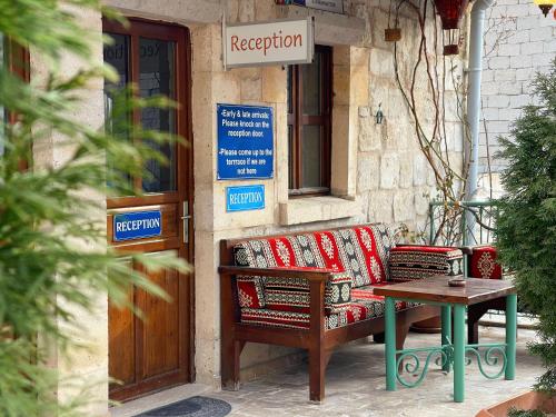 a bench and a table in front of a building at Gedik Cave Hotel in Goreme