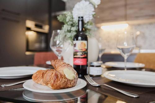 a table with a plate of bread and a bottle of wine at 1bed Mel Apt W Church Views By Homely Malta! in Mellieħa
