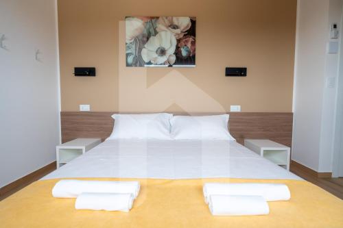 a large white bed with two white towels on it at Homiday - Villa Sofia in Atri