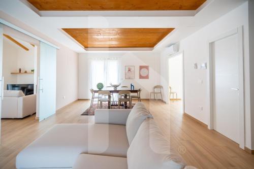 a living room with a white couch and a table at Homiday - Villa Sofia in Atri