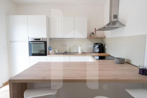 a kitchen with white cabinets and a wooden counter top at Homiday - Villa Sofia in Atri