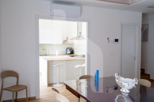 a kitchen with a glass table and chairs at Homiday - Villa Sofia in Atri