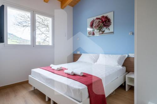 a bedroom with a white bed with a red blanket at Homiday - Villa Sofia in Atri